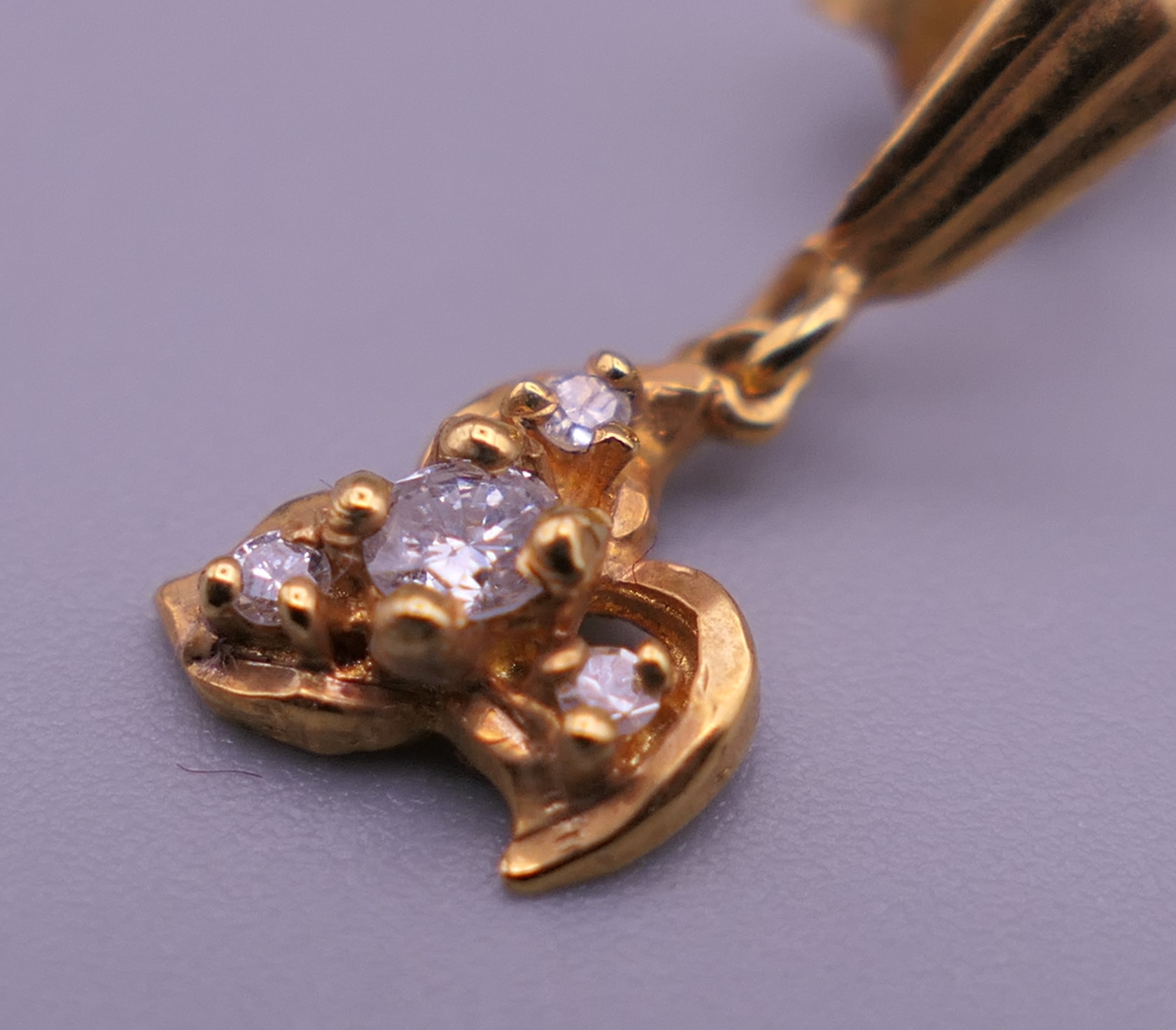 A pair of gold diamond set earrings. 1 cm high. 1.4 grammes total weight. - Image 4 of 5