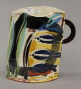 A signed Studio Pottery jug decorated with fish. 29 cm high.