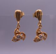 A pair of gold diamond set earrings. 1 cm high. 1.4 grammes total weight.