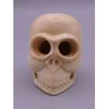 A carved bone model of a skull. 4 cm high.