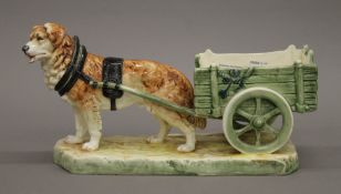 A Continental porcelain model of a St Bernard pulling a cart. 34 cm long.