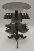 A 19th century carved oak three-tiered tripod table. 57 cm diameter.