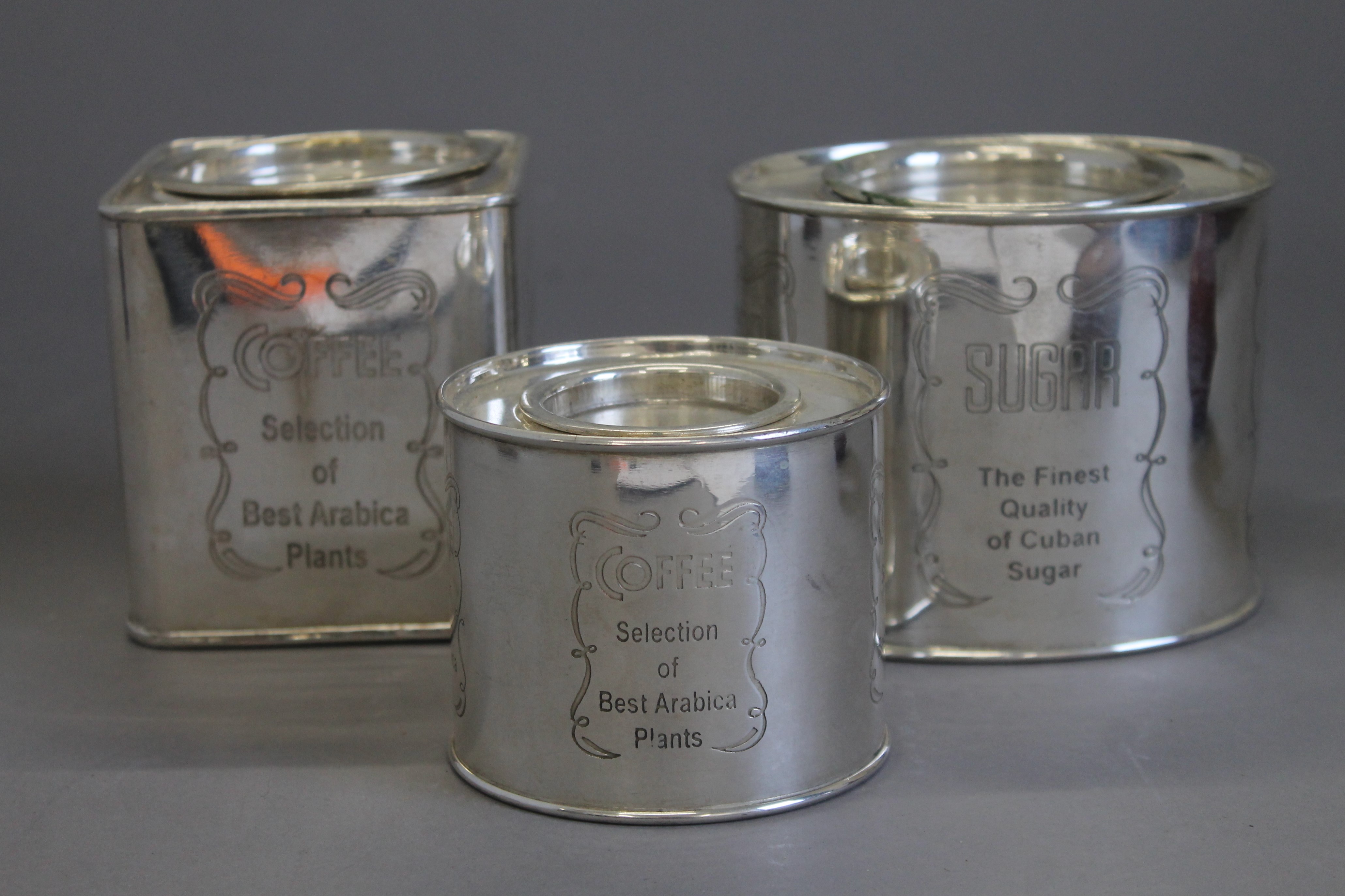 A set of three silver plated coffee and sugar tins.