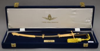 A cased Argentinean sword, the case bearing presentation label 'To Flying Officer M.J Dutton'.