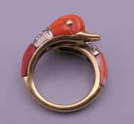 An 18 ct gold diamond and coral ring in the form of two dolphins.