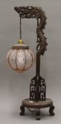 A Chinese carved wooden table lamp formed as a dragon. 71 cm high.