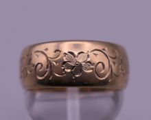 A 9 ct gold engraved wedding band. Ring size N/O. 6.2 grammes.
