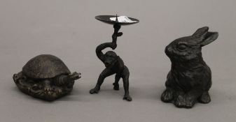 A monkey form candlestick, a model of a tortoise and a model of a rabbit. The former 10 cm high.