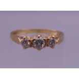 An 18 ct gold three stone diamond ring. Ring size J/K. 2 grammes total weight.