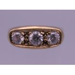 A 9 ct gold gentleman's three stone diamond ring. Ring size R/S. 5.1 grammes total weight.