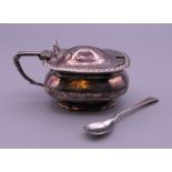 A silver mustard pot and a silver spoon. 113.8 grammes.