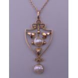 An Edwardian Arts Nouveau 9 ct gold pearl pendant on a gold chain.