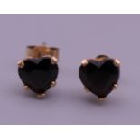 A pair of 9 ct gold and garnet heart shaped earrings. 5 mm high.