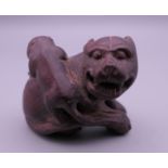 A wooden netsuke formed as two dogs-of-fo. 3.5 cm high.