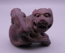 A wooden netsuke formed as two dogs-of-fo. 3.5 cm high.