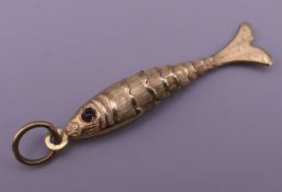 A 9 ct gold reticulated fish pendant. 4 cm high. 1.5 grammes total weight.