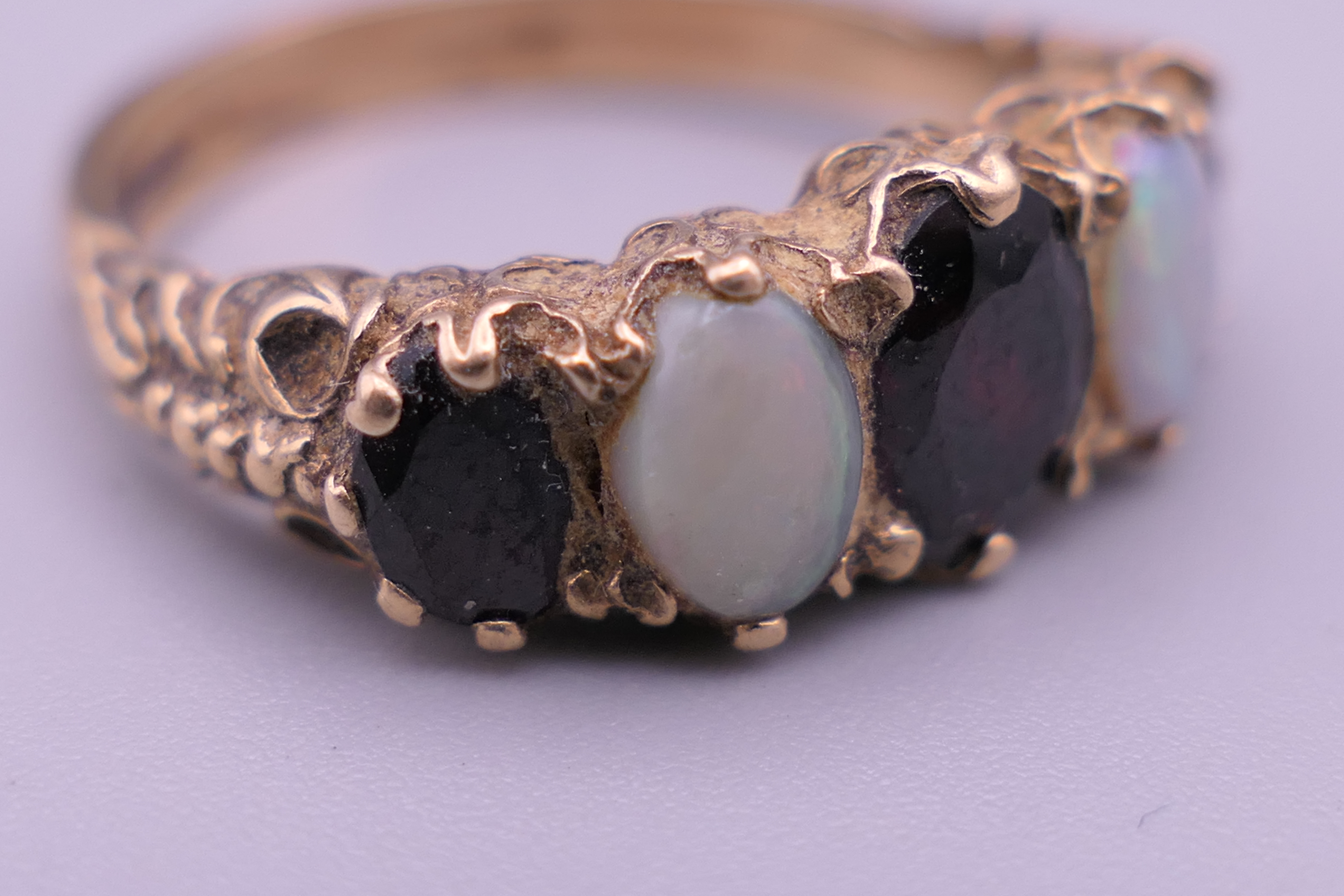 An unmarked gold, probably 9 ct gold, opal and garnet ring. - Image 3 of 7