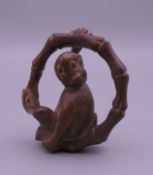 A wooden netsuke formed as a monkey. 4.5 cm high.