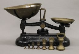 A set of kitchen scales with a set of 7 brass bell weights. 40 cm wide.