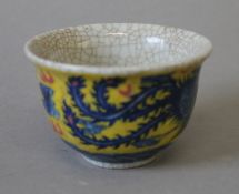 A Chinese yellow and blue porcelain dragon tea bowl. 9 cm diameter.