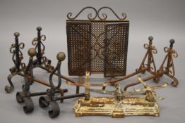 Three pairs of wrought iron andirons, a set of scales and a fireguard.