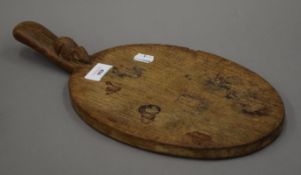 A Mouseman oak cheeseboard. 37.5 cm long.