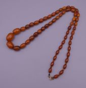 An amber necklace. Approximately 76 cm long.