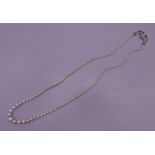 A single strand pearl necklace set with an 18 ct gold and diamond clasp. 50 cm long.