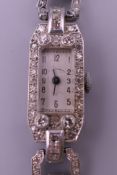 An Art Deco platinum diamond set ladies cocktail watch. 1.25 cm wide. 20.