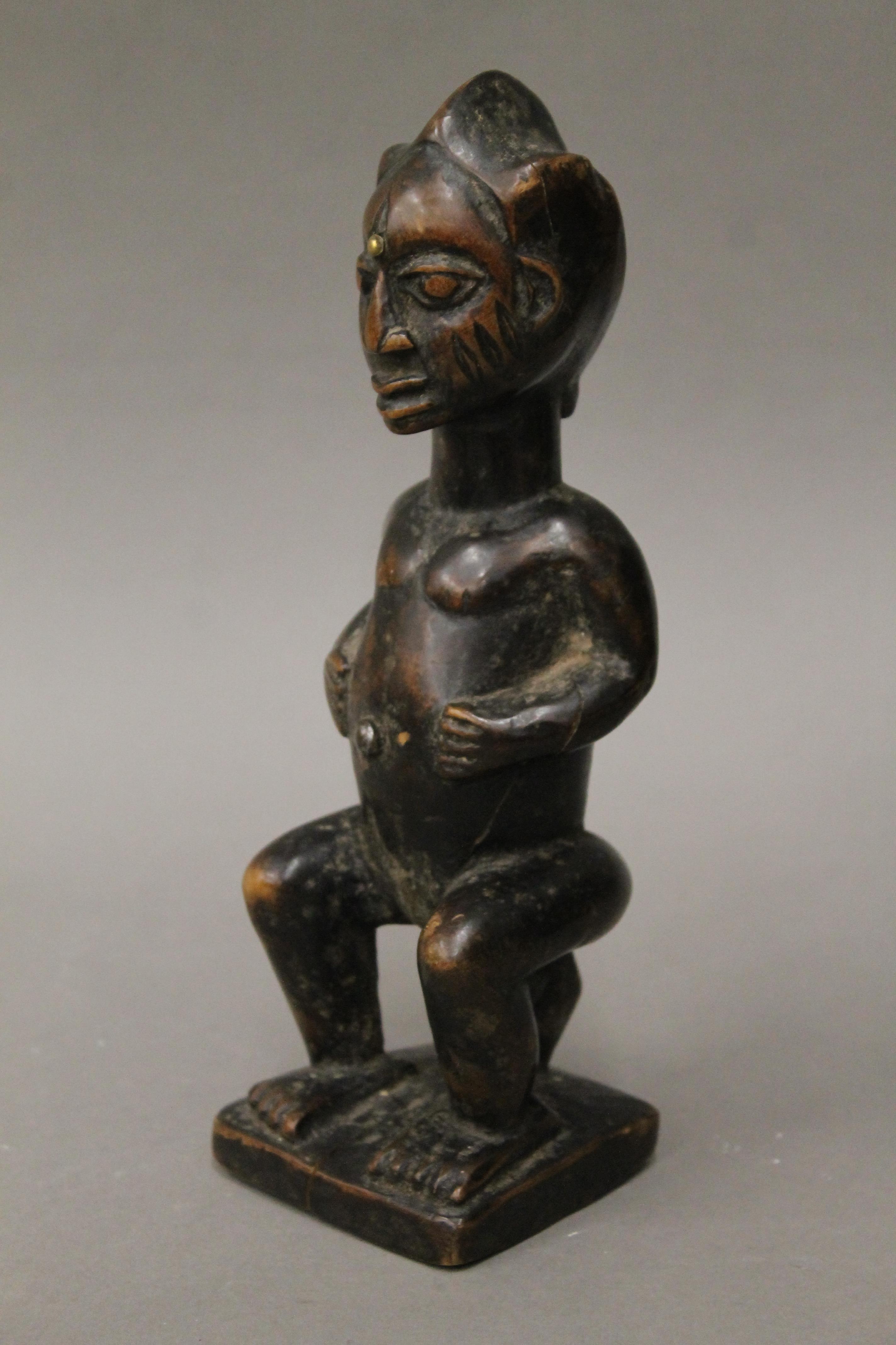 A tribal wooden figure with studded and scarified face. 23 cm high. - Image 2 of 4