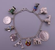 A silver charm bracelet with eleven charms. Bracelet 18 cm long. 30.3 grammes.