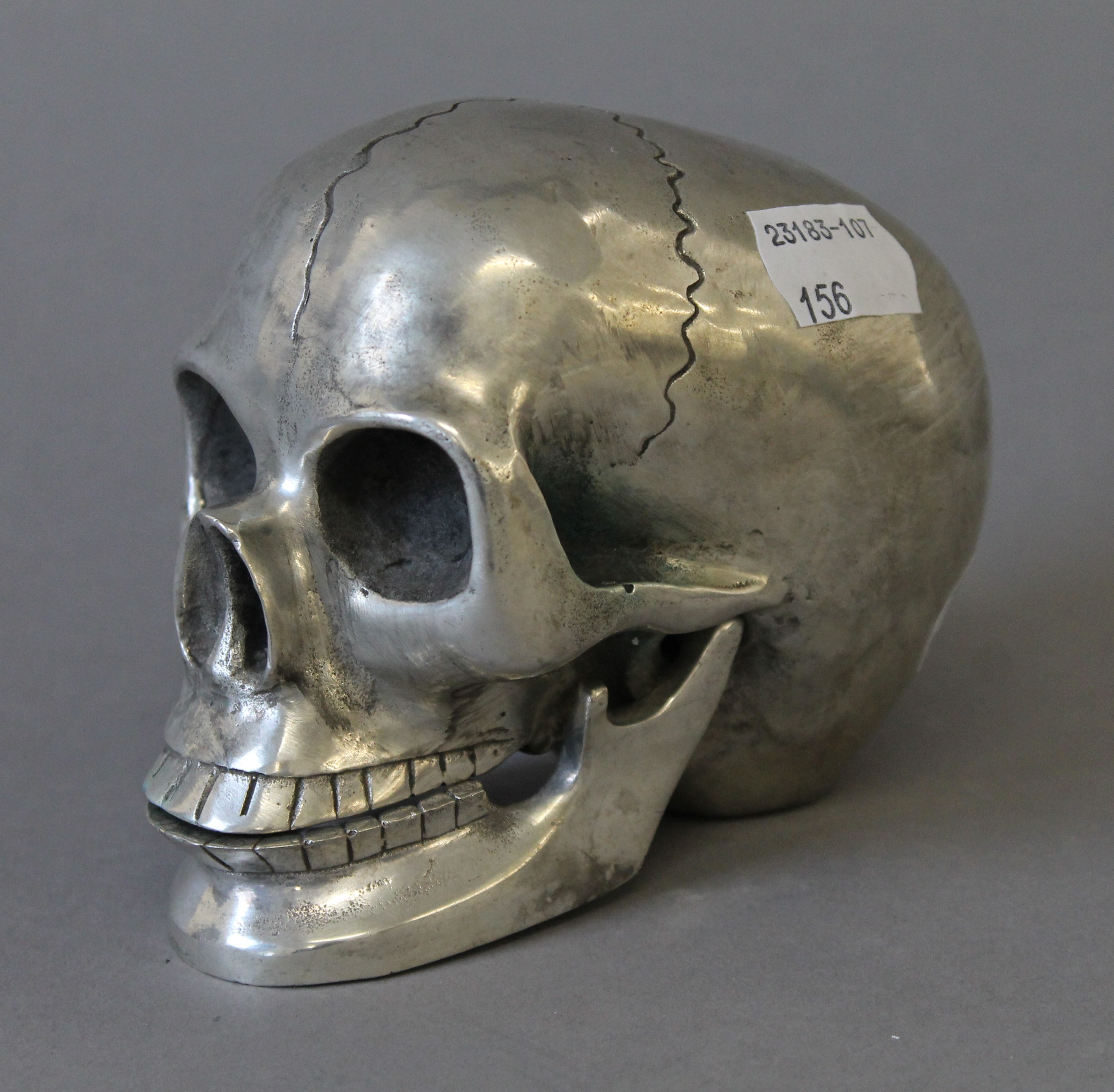 A silvered metal model of a skull. 9.5 cm high.