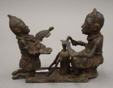 A Benin bronze figural group. 26 cm long.