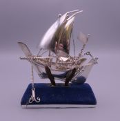 A silver model of a sailing boat on stand. Boat 8.5 cm high. 43.4 grammes.