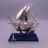A silver model of a sailing boat on stand. Boat 8.5 cm high. 43.4 grammes.