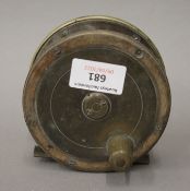 A vintage brass mounted fishing reel. 10.5 cm diameter.