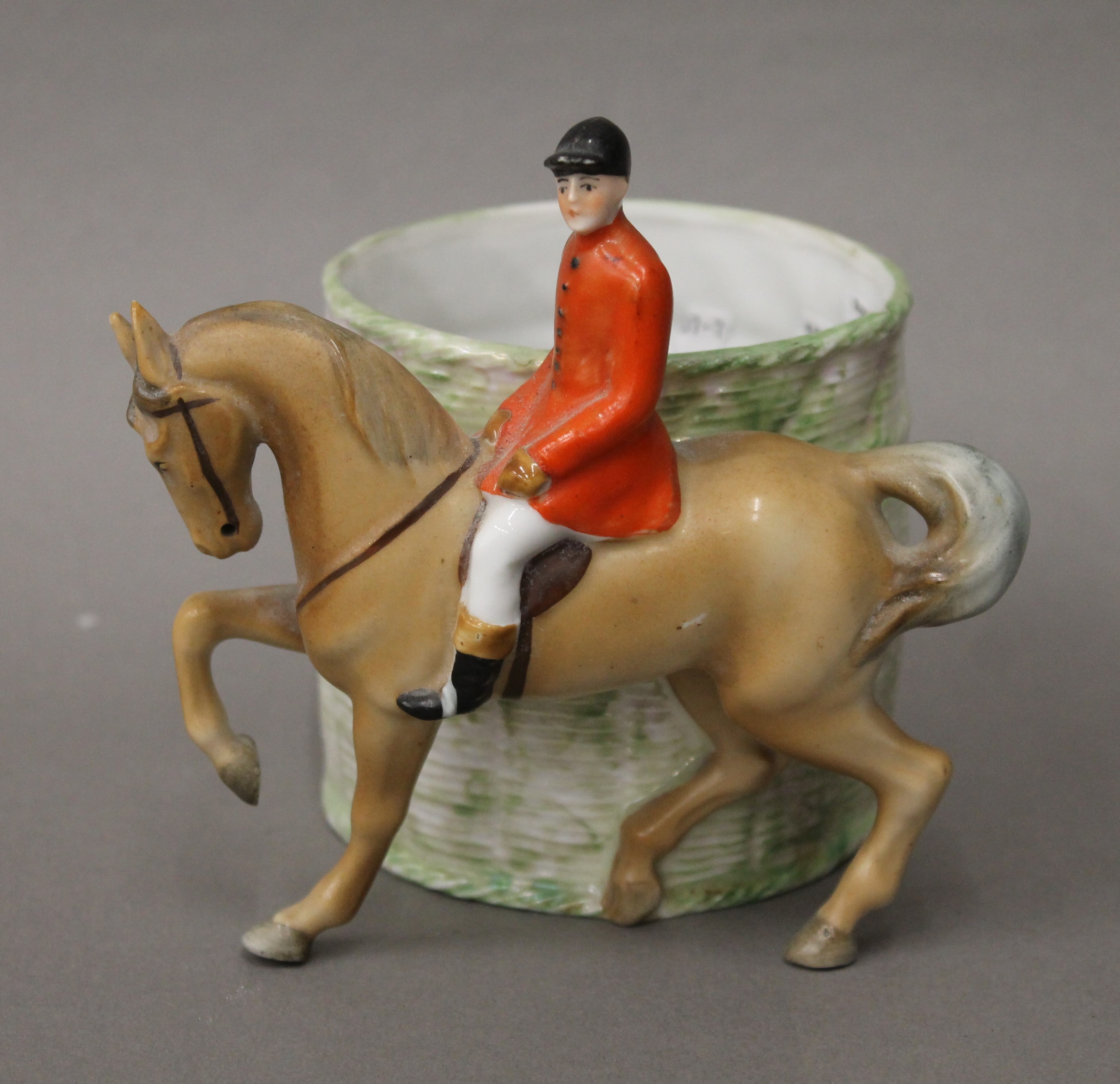 A late 19th/early 20th century porcelain vase surmounted with a huntsman. 13 cm high.