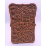 A Chinese carved wooden card case decorated with figures in a landscape. 10.5 cm x 7 cm.