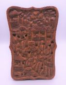 A Chinese carved wooden card case decorated with figures in a landscape. 10.5 cm x 7 cm.