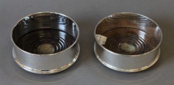 A pair of silver plated and wooden coasters. 12 cm diameter.