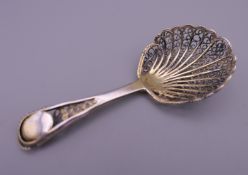 An early silver gilt filigree caddy spoon. 7.5 cm long. 8.1 grammes.
