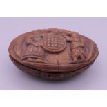 A carved coquilla nut snuff box. Approximately 7 cm wide, 2 cm high.