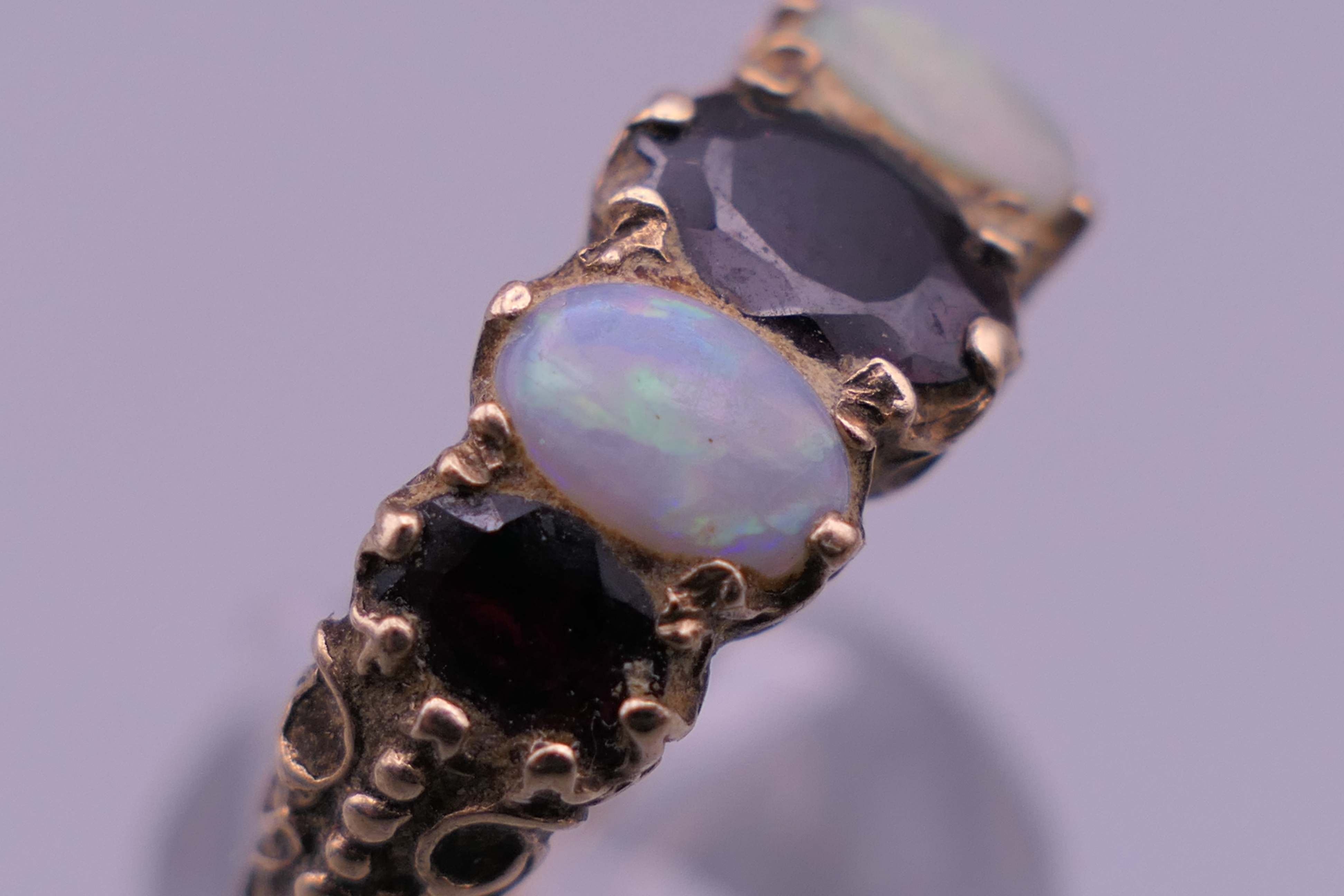 An unmarked gold, probably 9 ct gold, opal and garnet ring. - Image 4 of 7