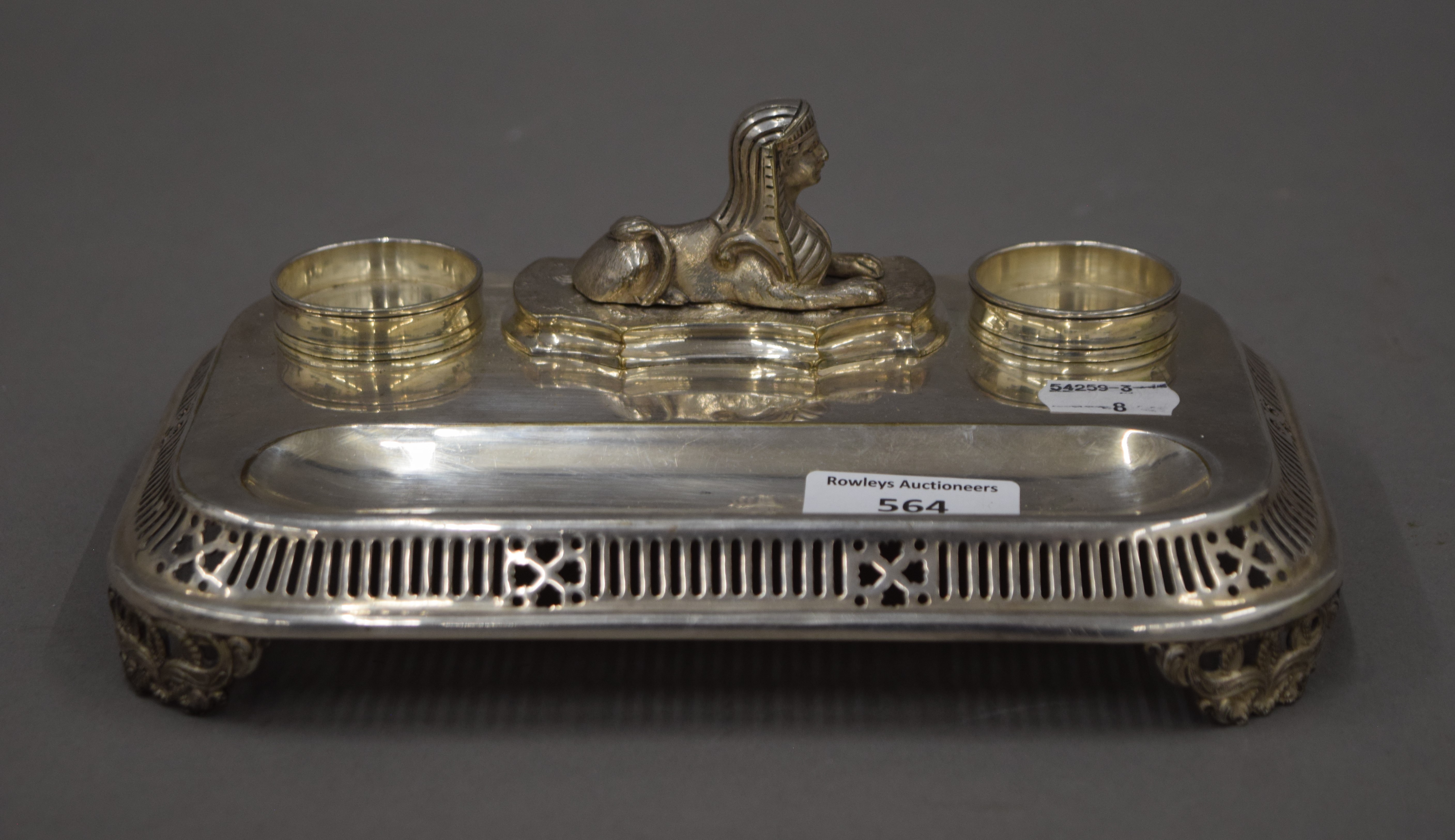 A silver plated desk stand surmounted with a sphinx. 21.5 cm wide.