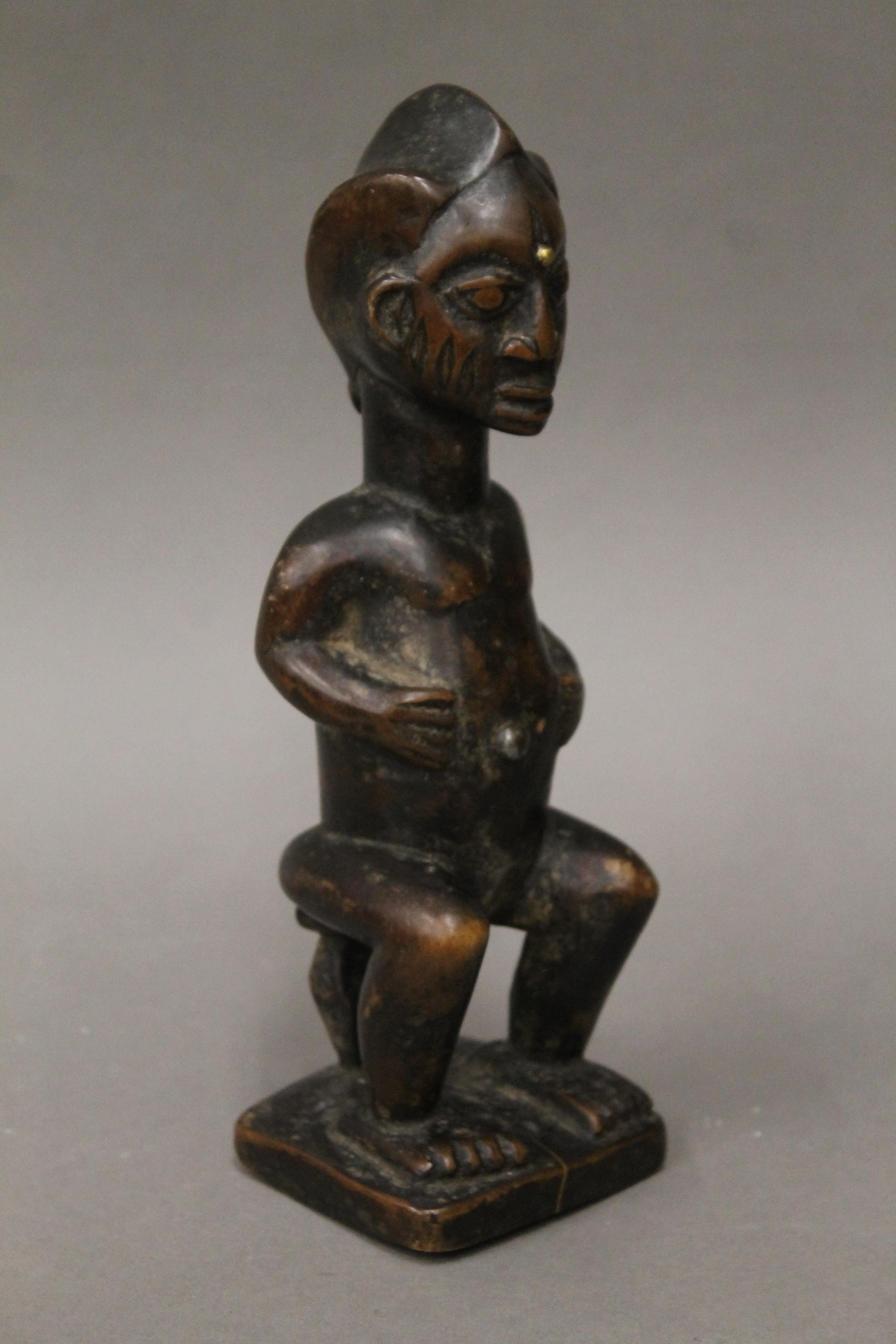 A tribal wooden figure with studded and scarified face. 23 cm high. - Image 3 of 4