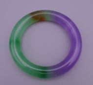 A two tone jade bangle. 6 cm internal diameter.