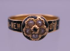 A Victorian 18 ct gold seed pearl and enamel mourning ring. Ring size N/O. 2.9 grammes total weight.