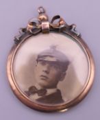 A WWI gold locket with a photograph of a naval officer. 3.25 cm diameter.