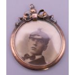 A WWI gold locket with a photograph of a naval officer. 3.25 cm diameter.