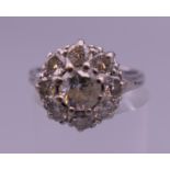 An 18 ct white gold diamond cluster ring. Ring size N. 4.5 grammes total weight.